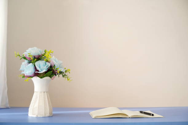 istock Blue flowers in vase and open notebook with pen on table 1294172532