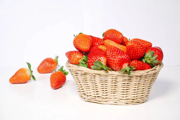 Wicker basket with fresh ripe tasty red strawberries on white background