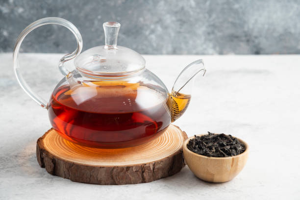 istock Dry tea leaves with teapot on a wooden board 1294172636