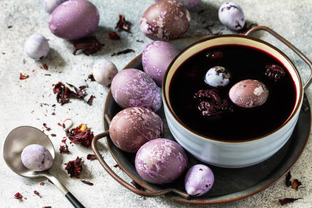 istock Natural Easter egg dye purple. Homemade Eggs are painted with natural egg dye from dried hibiscus flowers on a gray stone table top. 1294175535
