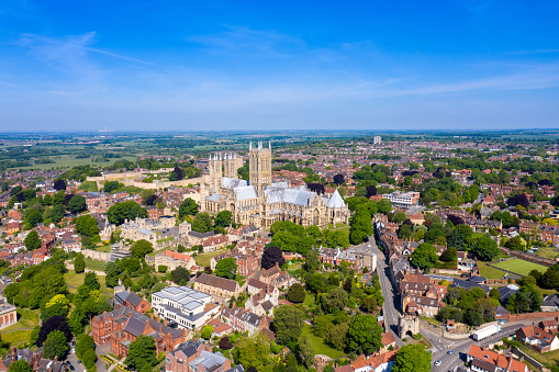 Aerial footage of the Lincoln Cathedral, Lincoln Minster in the UK city centre of Lincoln East Midlands on a bright sunny summers day showing the historic Cathedral Church in the British city centre