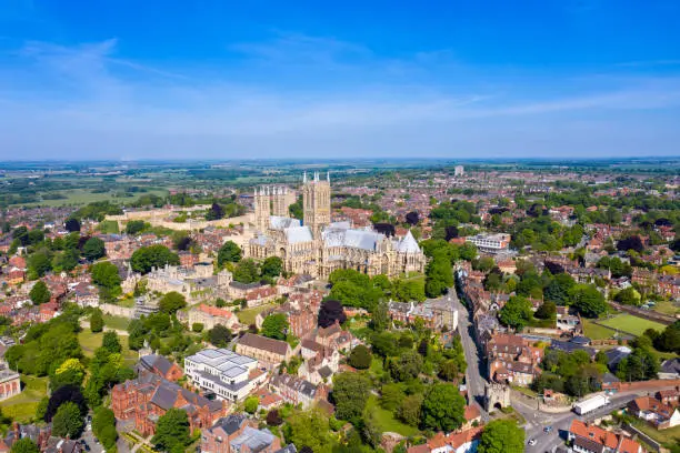 Photo of Aerial footage of the Lincoln Cathedral, Lincoln Minster in the UK city centre of Lincoln East Midlands on a bright sunny summers day showing the historic Cathedral Church in the British city centre