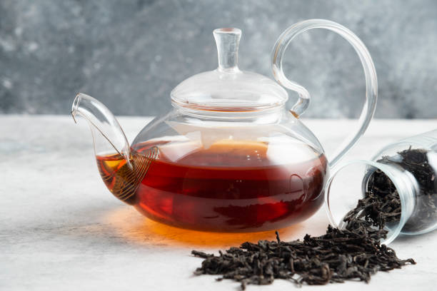 istock Dry tea leaves with teapot on a marble background 1294176397