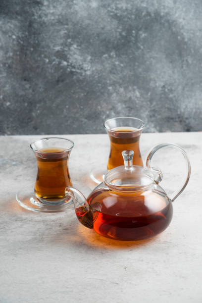 istock Two glass cup of tea with teapot on a marble background 1294176474