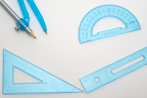 A blue plastic geometry set placed on white paper