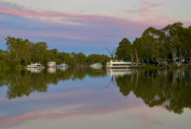 великолепный восход солнца, полосатый цветом на спокойной реке мюррей с плавучими домами в милдуре в австралии - mildura стоковые фото и изображения
