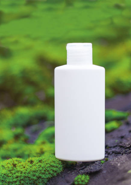 istock white bottle for cosmetic product stands on moss. 1294180904