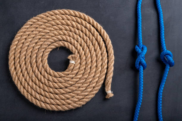 istock A rope coiled in a circle and two sailing knots. Accessories for sea wolves on the table. Dark background. 1294181798