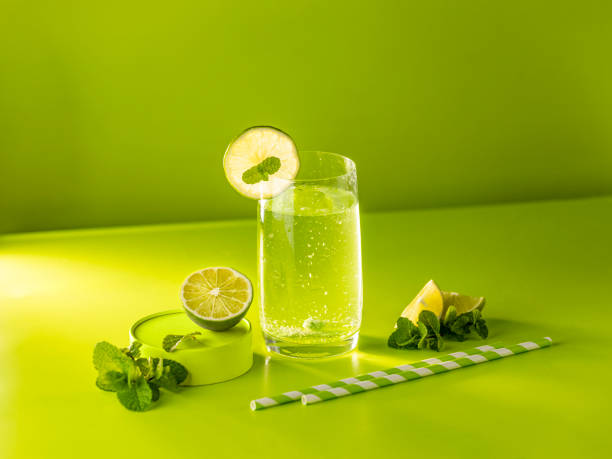 istock Creative drink background. Fresh Mojito cocktail with lime and mint in highball glass with water drops on green background in bright light, Mojito refreshing drinks. Summer vacation and party concept 1294183177