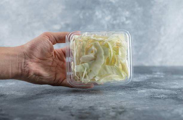 istock Man holding plastic container full of cheese to the camera 1294183858
