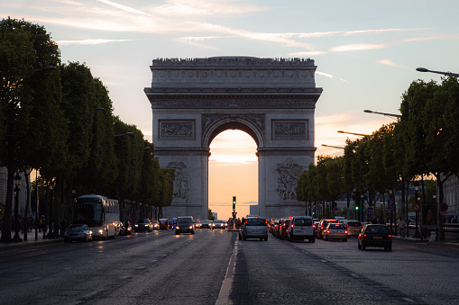 Motor traffic along the Champs-Elysess towards the famouse landmark Arc dr Triomphe on a summer's evening in Paris, France