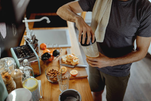 istock Young man is making a smoothie after exercising at home 1294185105