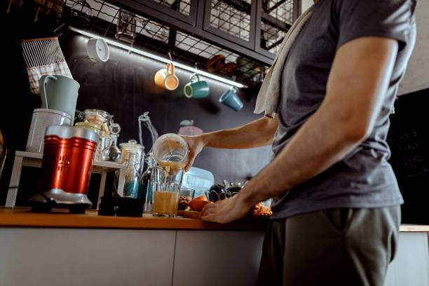 istock Young man is making a smoothie after exercising at home 1294185125