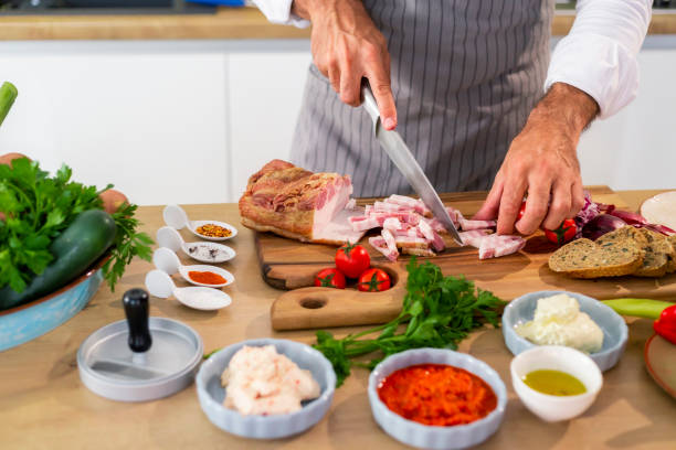 istock The cook is cutting bacon on a wooden board in kitchen 1294185243