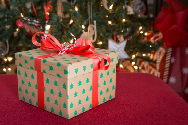 istock Christmas gift with tree in the background 1294186335