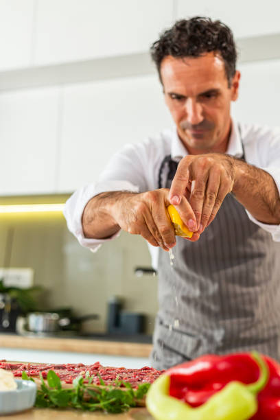 istock A cook who squeezes lemon juice on carpaccio meat 1294186345