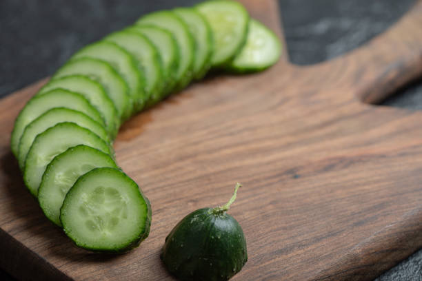 istock Wide angle sliced cucumber on black background 1294187545