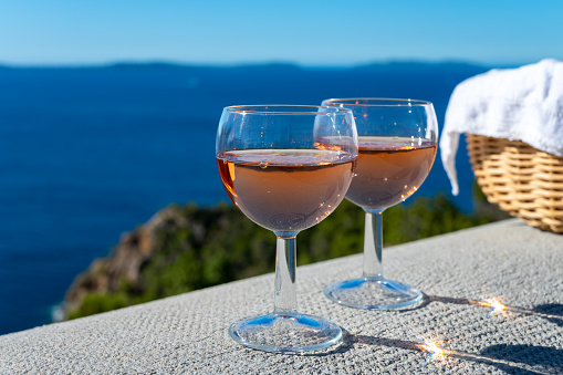 Drinking of local cold rose wine at sunset in summer with sail boats haven of Port grimaud on background, Provence, Var, France