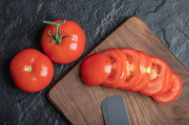 fermez-vous vers le haut de la vue des tomates fraîchement cueillies et juteuses sur le fond foncé de pierre - color image copy space high angle view isolated photos et images de collection