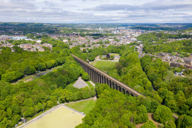 Aerial photo of a scenic view of the Lockwood Viaduct located in the town of Huddersfield borough of Kirklees in West Yorkshire showing the historic railway viaduct along side trees in the woods stock photo