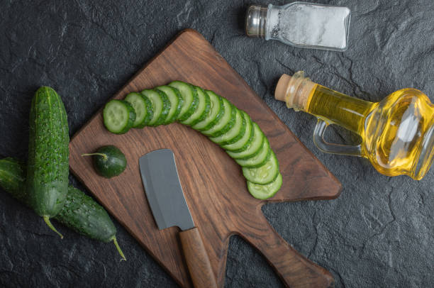 istock Sliced or whole cucumber on wooden board 1294199966
