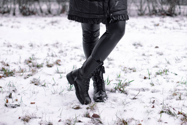 istock Female legs in black winter shoes 1294200600