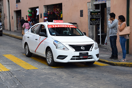 Merida, Mexico - 4th January, 2018: Nissan Versa vehicle in taxi version driving on a street. The Versa is a popular modern sedan in Central America.