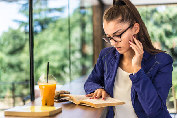istock Young beautiful woman reading a book in a cafe. 1294201992