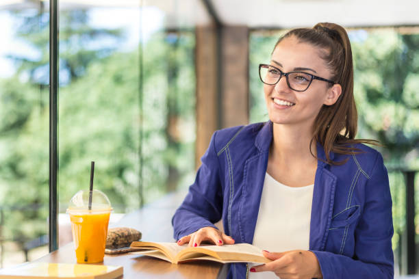 istock Young beautiful woman reading a book in a cafe. 1294201993