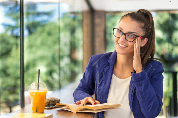 istock Young beautiful woman reading a book in a cafe. 1294201996