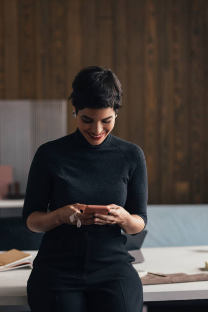 istock Happy Young Woman Using her Phone at Work 1294202834