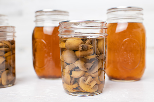 Mushrooms and broth canned the old fashioned way at home on white background.