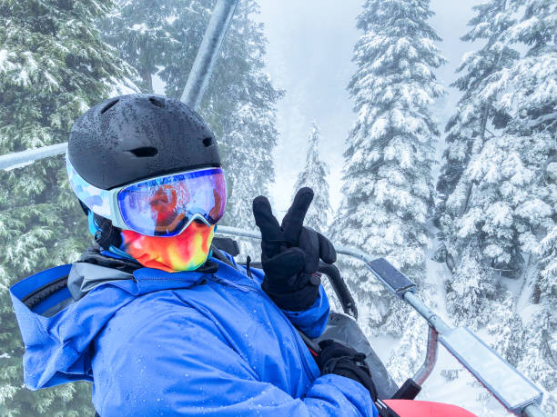 woman skier wearing helmet, goggles, neck gaiter giving peace sign - mt seymour provincial park imagens e fotografias de stock