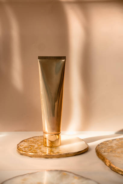 Golden cosmetic tube on pastel color minimalism beauty Golden cosmetic tube light pastel color background, lights and shadows. Natural minimalism. Minimal still life. Beauty blogging, branding layout,  skin care ad mock up, copy space bathtub photos stock pictures, royalty-free photos & images