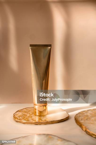 Golden Cosmetic Tube On Pastel Color Minimalism Beauty Stock Photo - Download Image Now