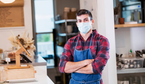 istock Hispanic man working in cafe with mask during covid-19 1294217174