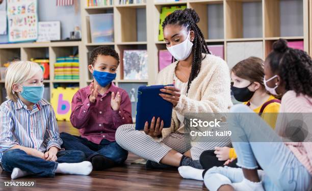 Preschool Teacher Students In Class Wearing Masks Stock Photo - Download Image Now