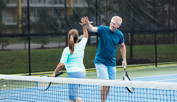 istock Couple playing tennis, high five 1294218709