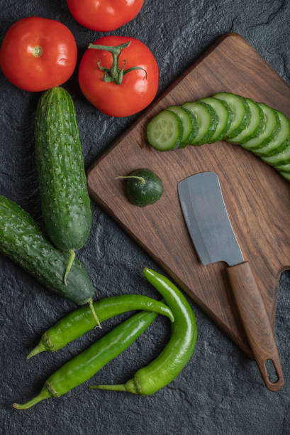 istock Fresh vegetables sliced on a wet black table. Tomato and cucumber slices 1294219928