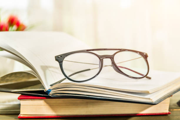 istock Reading glasses put on open book beside the window 1294221311