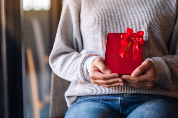 istock a woman holding a red present box 1294221617