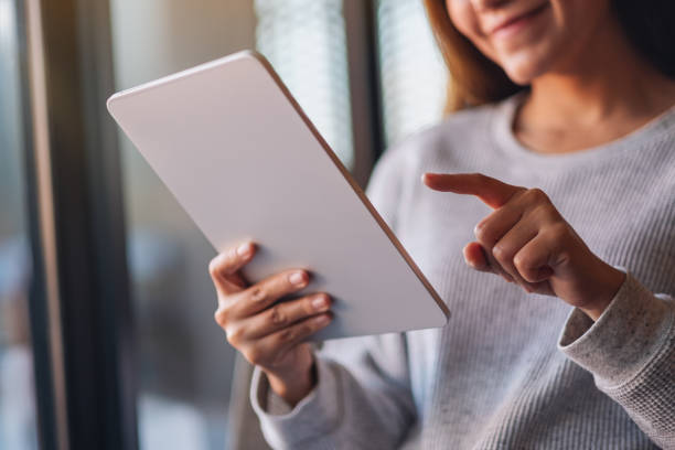 istock a beautiful young asian woman holding and using digital tablet 1294221627