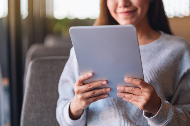 istock a beautiful young asian woman holding and using digital tablet 1294221634
