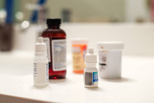 Medicine Bottles on Bathroom Counter 5 Different bottles of medicine sitting on a white bathroom counter eyedropper stock pictures, royalty-free photos & images