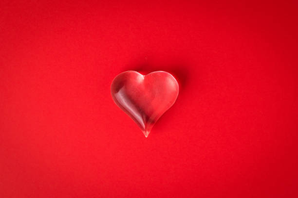 istock A glass heart on a bright red background. 1294231342