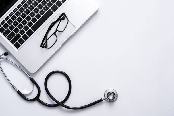 istock Top view of doctor office work space with stethoscope and laptop with copyspace for your text 1294236601