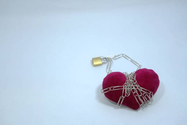 istock Fuchsia heart-shaped decoration and lock chain on light blue pastel background 1294238279