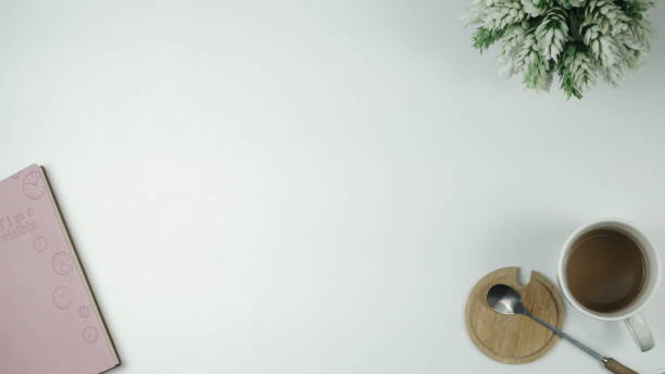 istock Top view of workspace, diary, flowers, coffee, white background, flat lay, copy space 1294239034