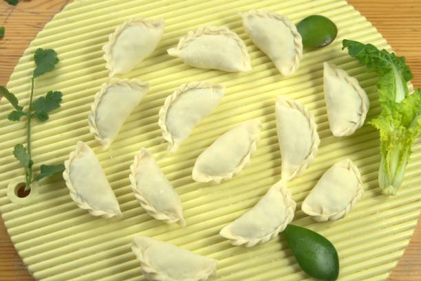 istock Uncooked raw dumplings with vegetables decor lying on a tray 1294239161