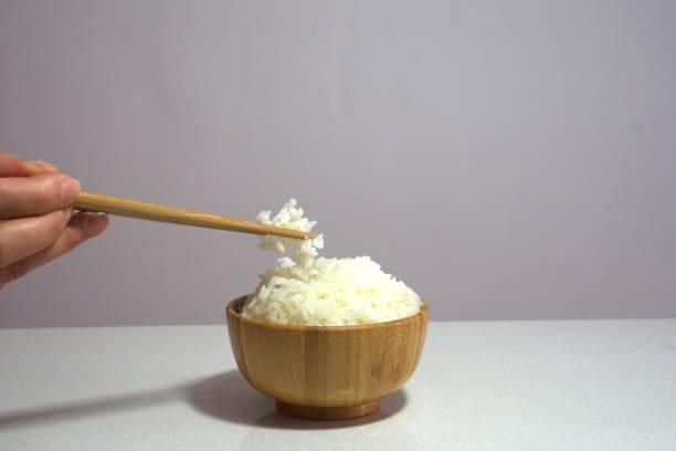 istock Eating rice in wooden bowl with chopsticks. Copy space. 1294240188